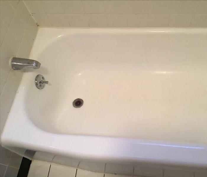 The same bathtub shown wite and shining after cleaning