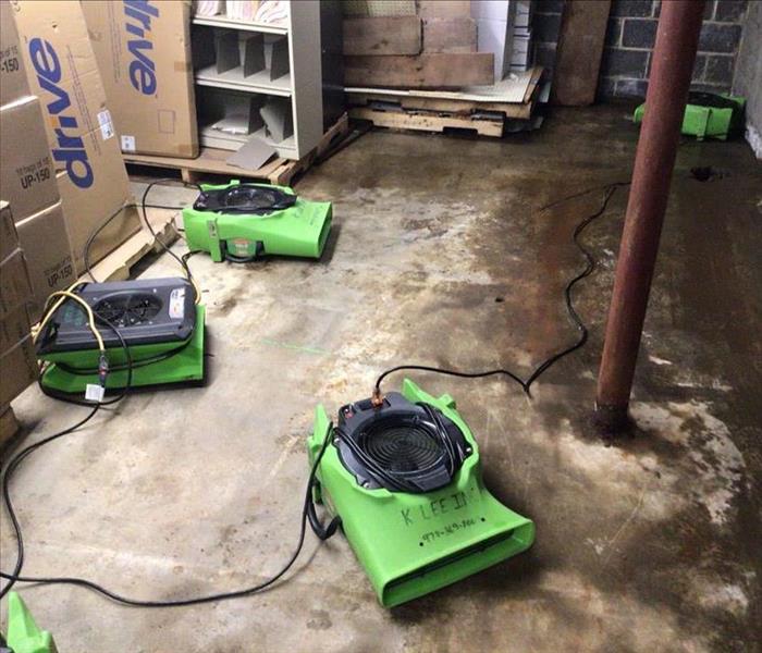 Basement with a wet floor and SERVPRO drying equipment