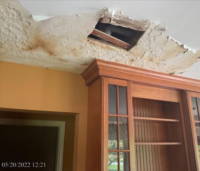A home with extensive water staining and crumbling drywall on the ceiling