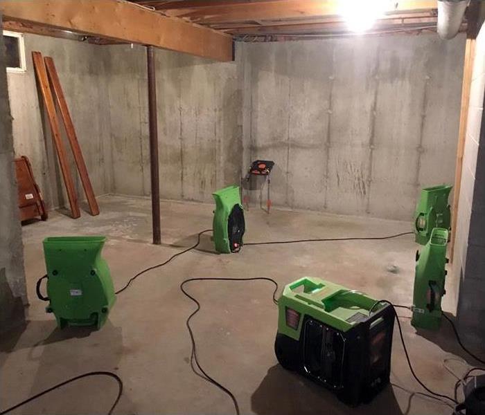 Dry and clean basement with air movers and dehumidifiers visible.