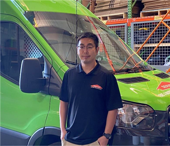 A man standing in front of a SERVPRO truck. 