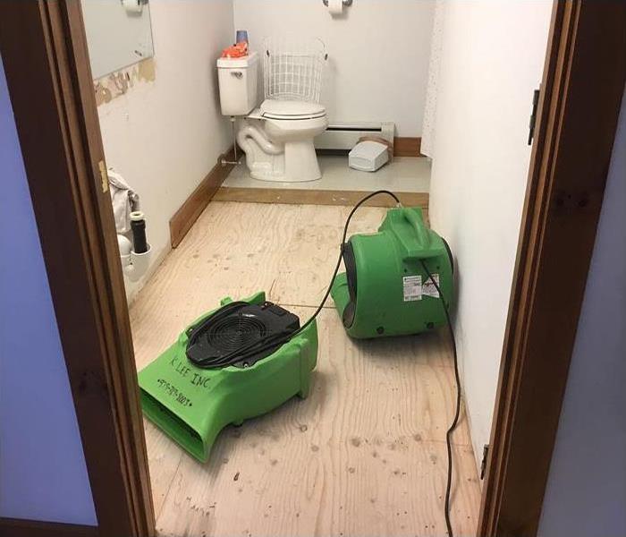 drying equipment in water damaged bathroom