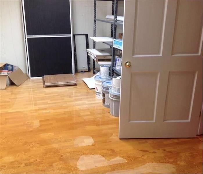 Standing water on a wood floor in a home office