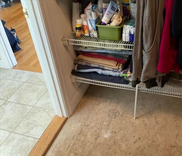 Exposed subfloor in a residential master closet with some water stains
