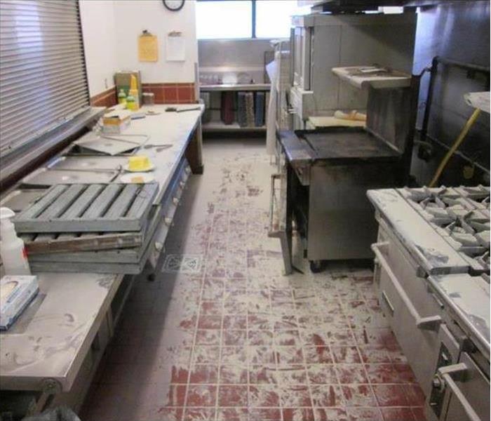A restaurant kitchen after the fire suppression system has discharged and fire retardant residue is all over everything