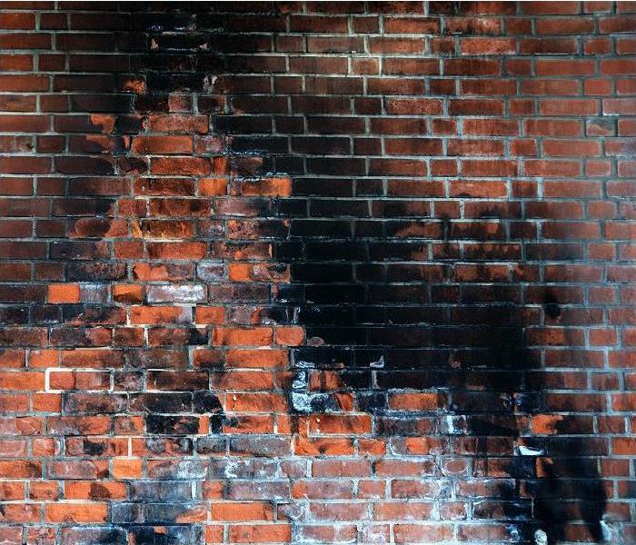 soot and smoke damage on a brick wall