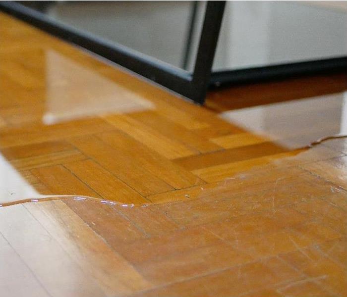 Close up of water flooding on living room parquet floor in a house