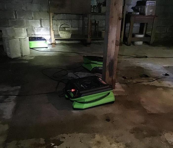 water damaged basement; SERVPRO drying equipment removing being used to remove water