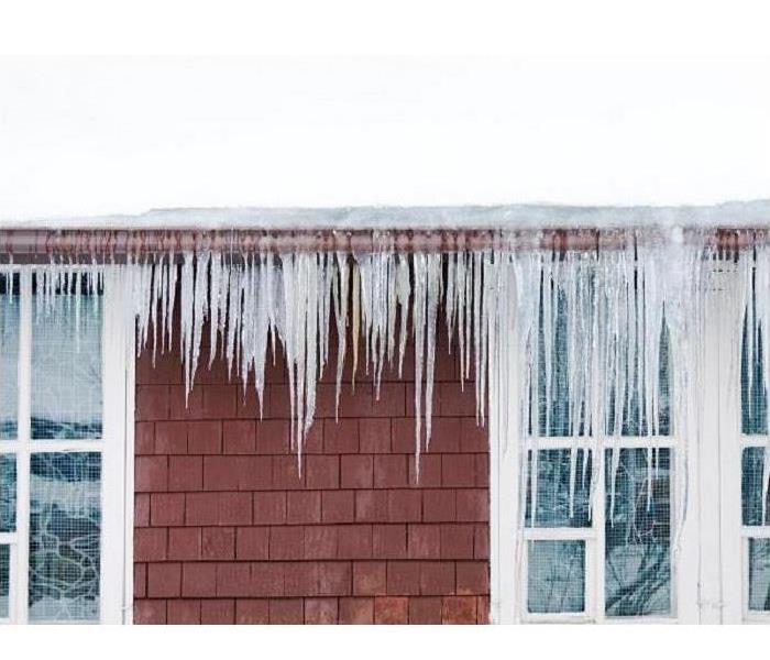 A gutter with icicles hanging from the gutters. 