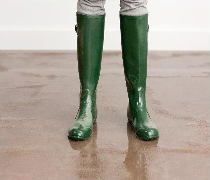 flood damaged home - image of boots on wet floor