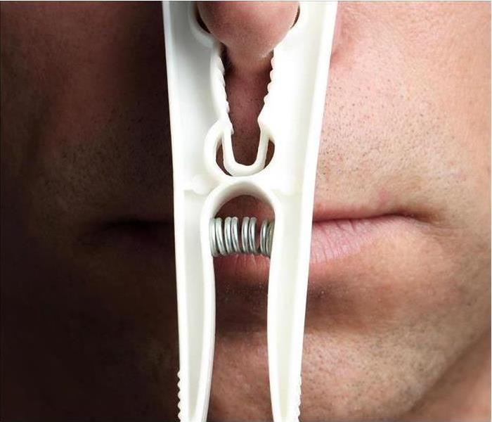 A man with a white clothespin on his nose. 